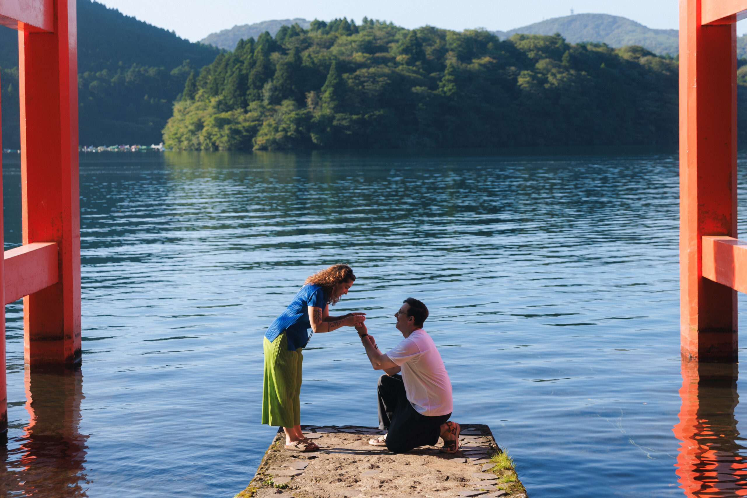 Surprise proposal photo shoot at Hakone Shrine’s Peace Torii gate with Lake Ashi and mountain views, capturing natural and candid moments.