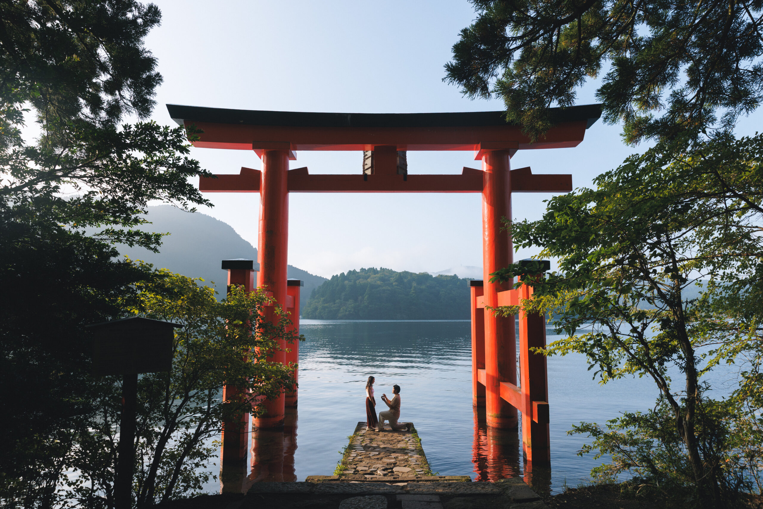 Surprise proposal in Hakone on a clear September morning, with blue skies and autumn light filtering through the trees, capturing emotional tears even without Mt. Fuji.