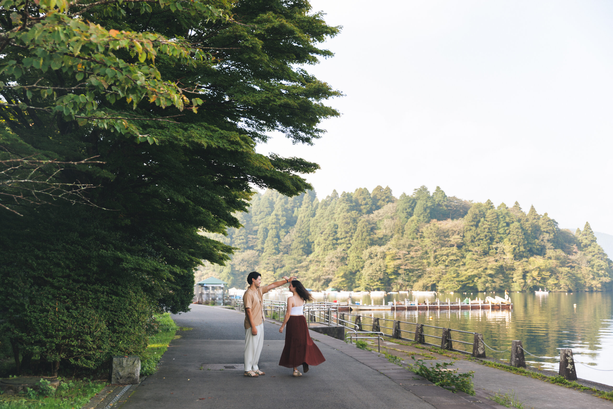 Surprise proposal in Hakone on a clear September morning, with blue skies and autumn light filtering through the trees, capturing emotional tears even without Mt. Fuji.
